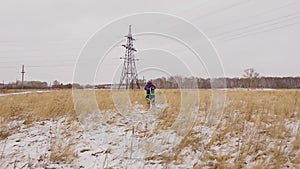 Electrician engineer going to the electric line on the snow field