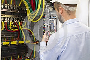 Electrician engineer at work inspecting cabling connection of high voltage power electric line photo