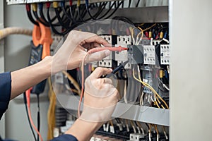 Electrician engineer work tester measuring voltage and current of power electric line in electrical cabinet control , concept chec