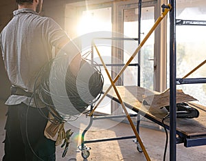 A worker at a construction site holds an electrical cable