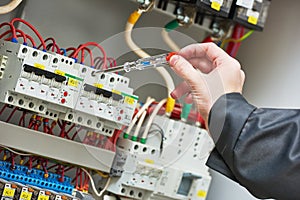 Electrician examining current voltage with screwdriver tester