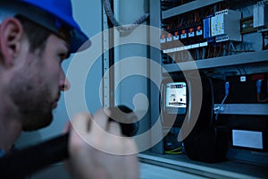 Electrician Examining A Fuse Box