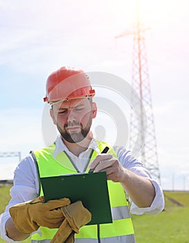 An electrician in the fields near the power transmission line. T