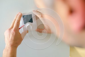 Electrician fitting a thermostat