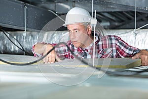 Electrician fixing neon on ceiling