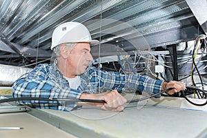 Electrician fixing neon on ceiling
