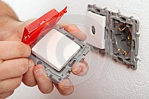 Electrician hand changing or installing an electrical switch