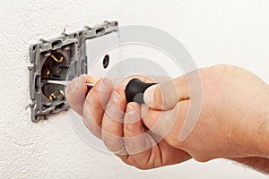 Electrician hand mounting a wall fixture