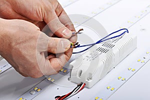 Electrician hands connect wires of led lamp