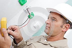 Electrician hands installing wall socket