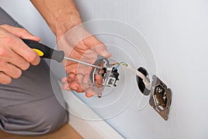 Electrician hands installing wall socket