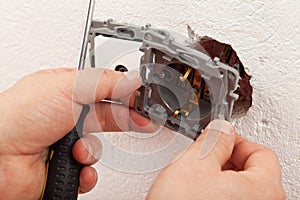 Electrician hands mounting electric wall fixture