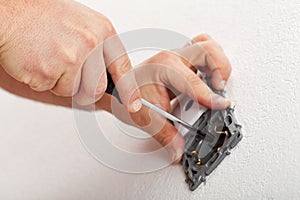 Electrician hands mounting electrical wall fixture