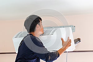 Electrician installing air conditioner unit, Technician man installing an air conditioning in a client house, Repairman fixing air