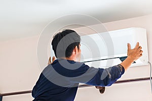 Electrician installing air conditioner unit, Technician man installing an air conditioning in a client house, Repairman fixing air