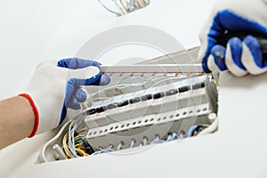 Electrician installing an electrical fuse box .