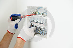 Electrician installing an electrical fuse box . photo