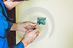 Electrician installing an electrical thermostat in a new house