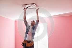 electrician installing a led light on the ceiling.