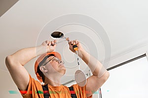 The electrician is installing an LED spotlight