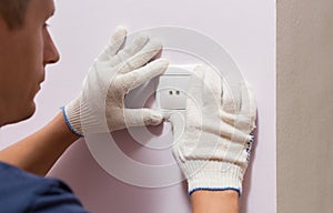 Electrician installing light switch, close up photo