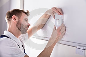 Electrician Installing Security System Door Sensor