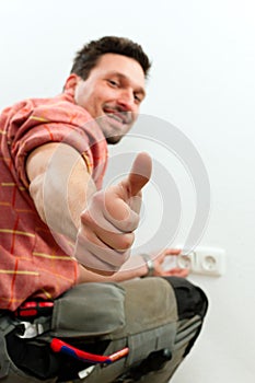 Electrician installing socket photo