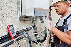 Electrician installing solar panel system, wiring inverter and electric box