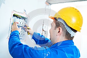 Electrician installing switching electric actuator in fuse box