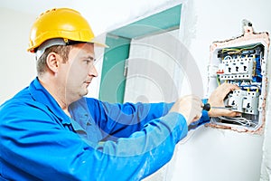 Electrician installing switching electric actuator in fuse box