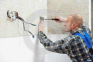 Electrician installing wall outlets