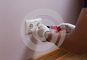 Electrician installing a wall power socket, close up photo