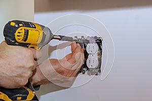 Electrician installs lighting switch in the wall