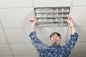 Electrician installs lighting to the ceiling.