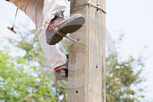 Electrician lineman repairman worker at climbing work on electric post power pole