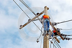 Electrician lineman repairman worker at climbing work on electric post power pole