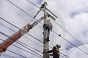 Electrician lineman repairman worker at climbing work on electric post power pole