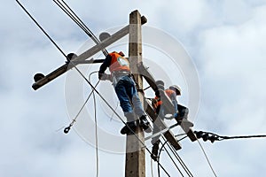 Electrician lineman repairman worker at climbing work on electric post power pole