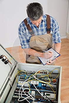 Electrician looking at fuse box