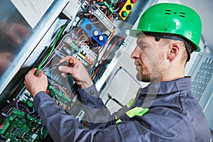 Electrician make maintenance in engine room of elevator