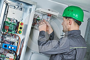 Electrician make maintenance in engine room of elevator