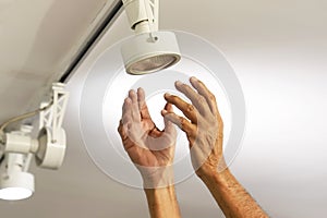 Electrician male man worker installing a ceiling LED spotlight