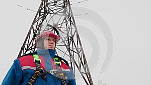 Electrician man standing on the power line and open helmet