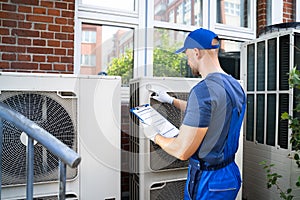 An Electrician Men Checking Air Conditioning Unit