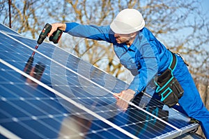 Electrician mounting solar panel on roof of modern house