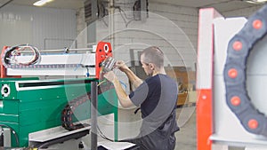 Electrician in overalls is working with energy panel and machinery equipment on plant