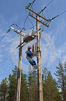 Electrician perform maintenance on the transmission towers recloser