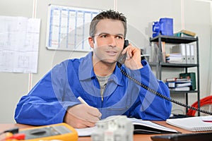 Electrician on phone in office