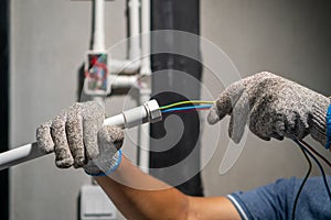 Electrician pulling wire into PVC Conduit
