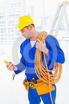 Electrician reading multimeter in bright office